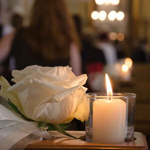 White candle and rose at a funeral service