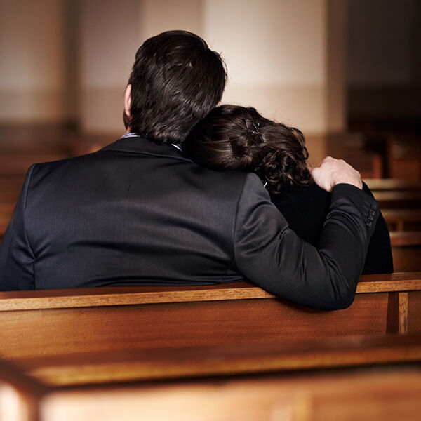 A man comforting a woman at a funeral
