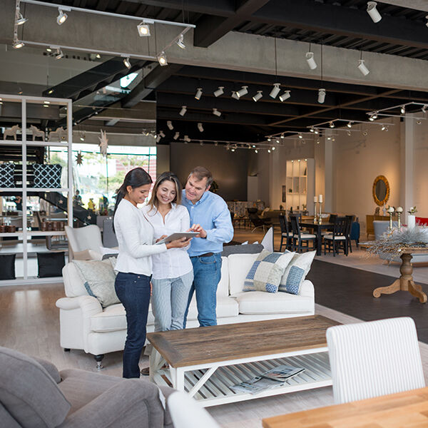 Man and woman discussing their furniture needs with a salesperson in a furniture store