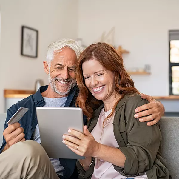 Middle-aged couple using iPad to shop online